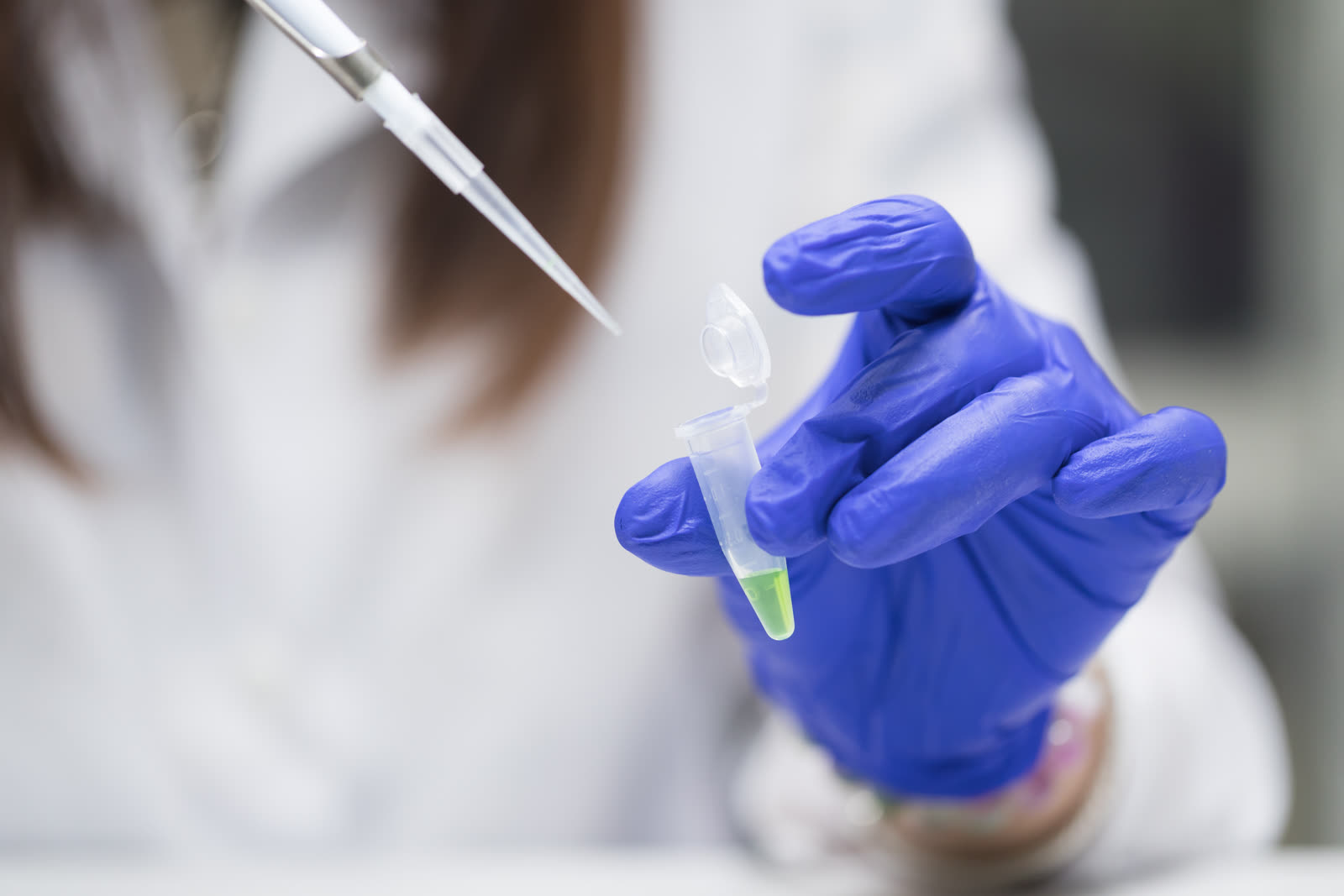 Scientist using a pipette and test tube to examine samples in a research laboratory