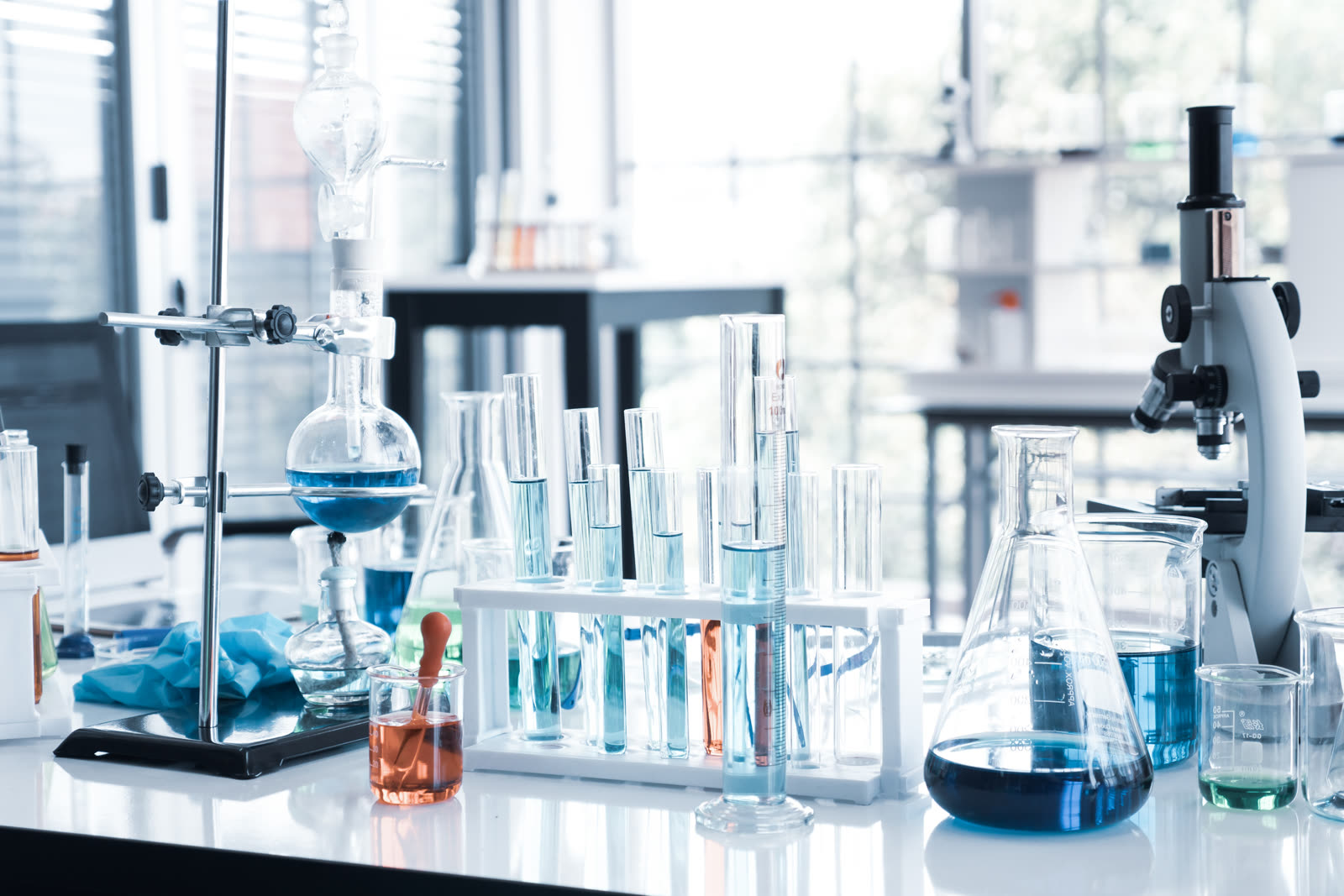 Laboratory bench with glassware, test tubes and a microscope