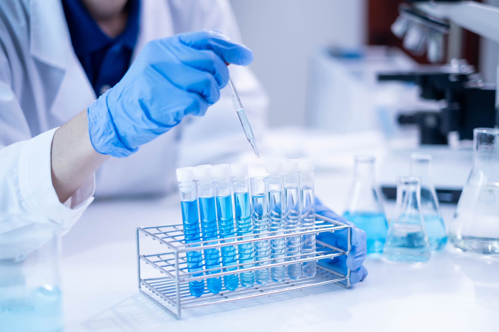 Blue laboratory glassware and pipette on a research bench