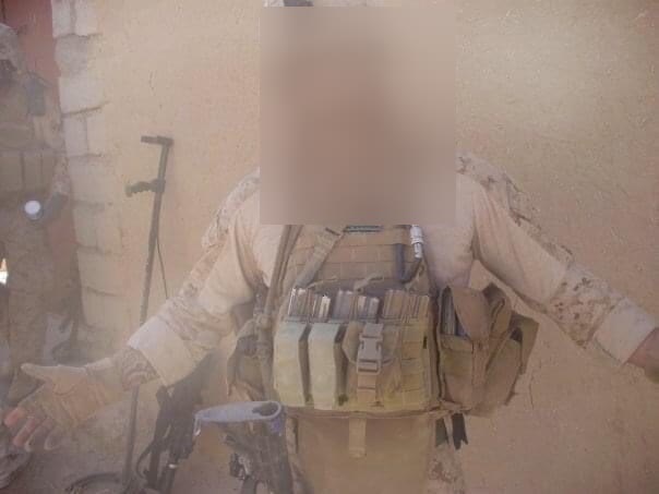 US Marine in helmet and plate carrier in blowing dust