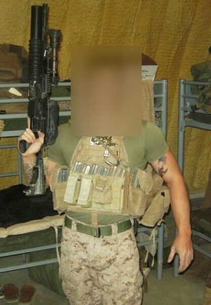 US Marine in a plate carrier with rifle inside a field billet