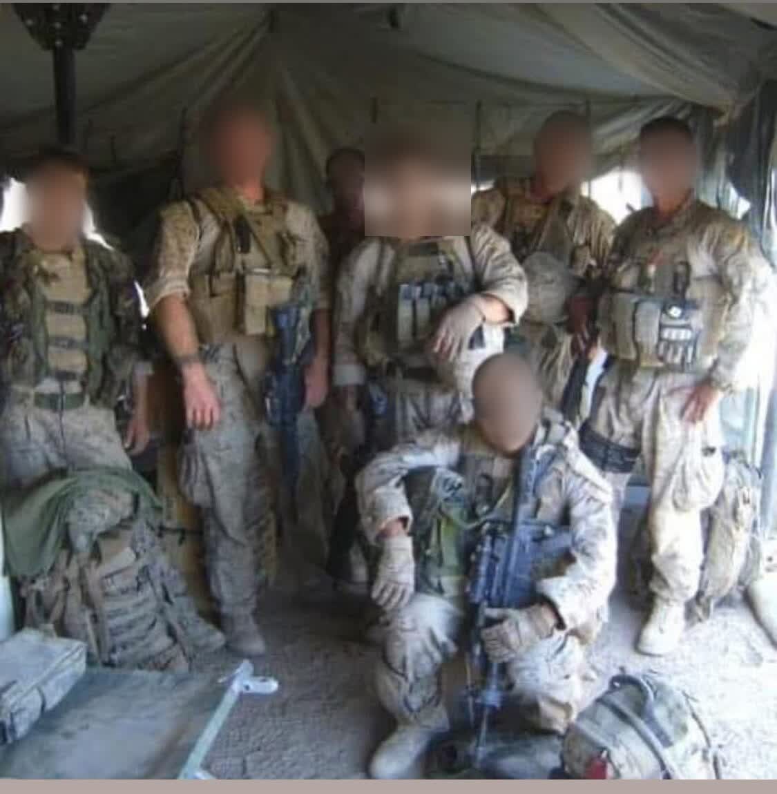 A squad of US Marines in full kit inside a field tent